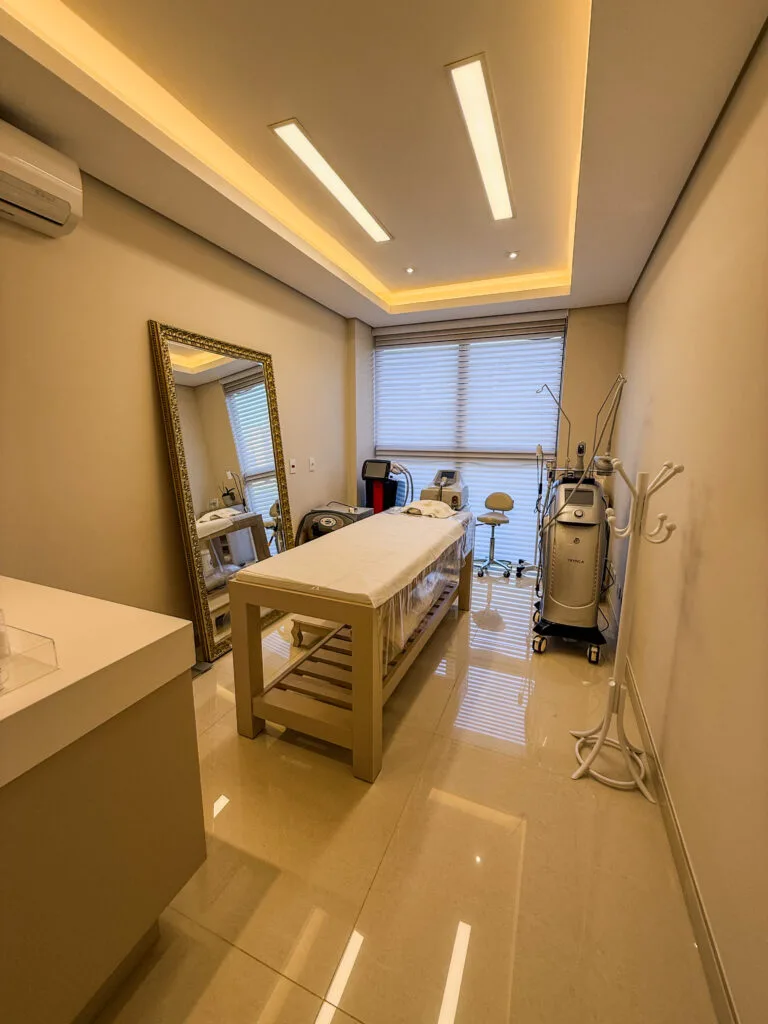 Sala de atendimento moderna e bem iluminada, equipada para procedimentos estéticos e dermatológicos, oferecendo conforto e tecnologia para os pacientes em Curitiba.